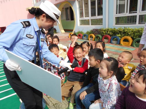 交警大队女子班成员和幼儿一起做交通安全小游